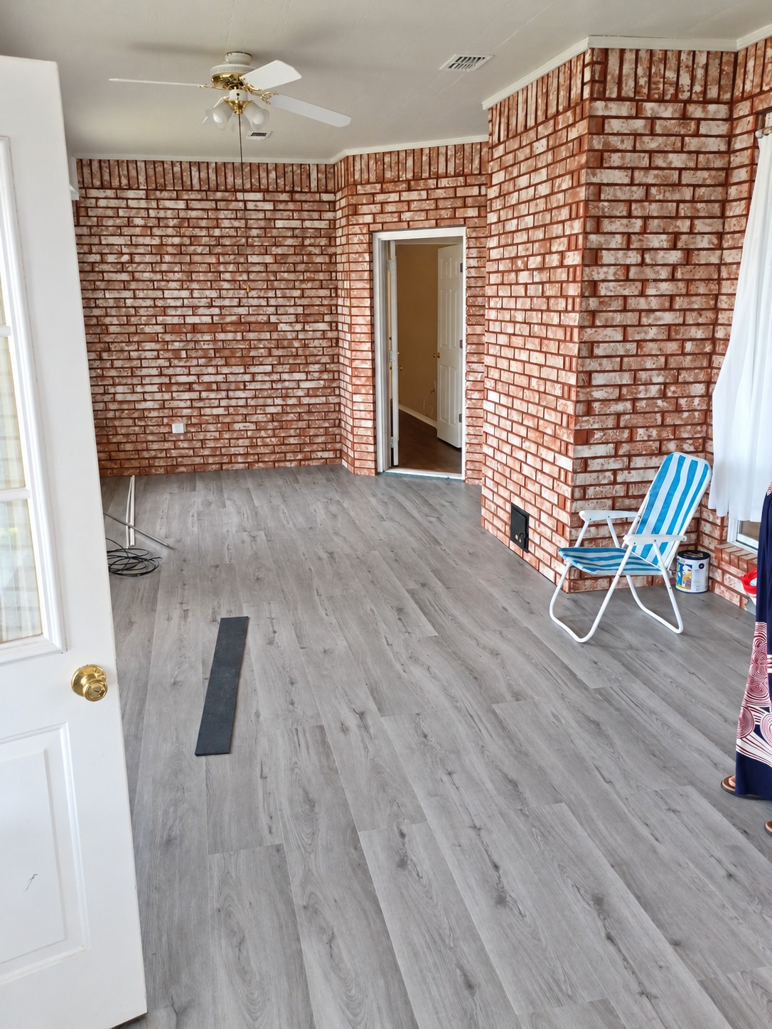 A closer look at flooring installation in a brick-walled room.
